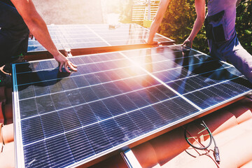 Workers assemble energy system with solar panel for electricity and hot water