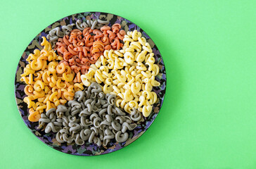 Italian green multicolored pasta with tomato and basil flavor top view