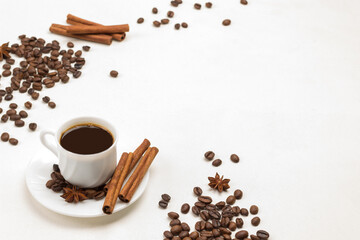 Cup of coffee, cinnamon sticks and star anise on saucer