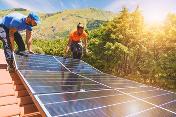 Workers assemble energy system with solar panel for electricity and hot water - obrazy, fototapety, plakaty