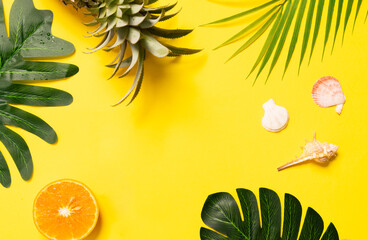 Fototapeta na wymiar Summer concept with seashell, orange and leaf on yellow background