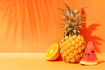 Summer concept with orange, pineapple and watermelon and orange background
