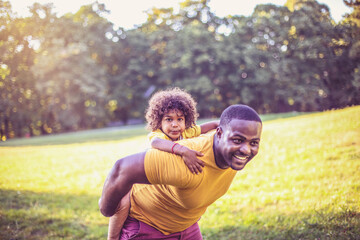 African American father and daughter having fun outdoors.