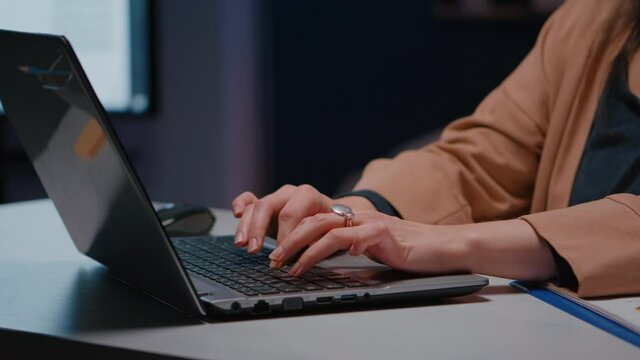 Close-up of businesswoman hands on keyboard sitting at desk in startup company office planning economic project on internet. Executive manager typing financial statistics answering business email