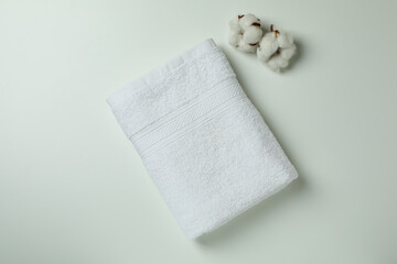 Clean folded towels and cotton on white background, top view