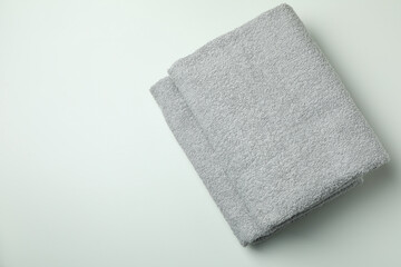 Clean folded towels on light gray background, space for text