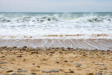 Vagues arrivant sur une plage de sable avec l'horizon en fond