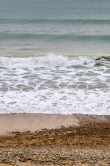 Vagues arrivant sur une plage de sable avec l'horizon en fond