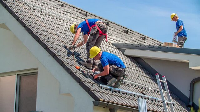 Men roof workers measure roof for solar panel construction
