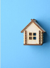 Miniature wooden house on a colored background. Concept of buying an apartment, house, real estate. Copy space.