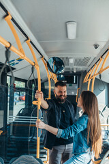 Couple standing in a moving bus and talking