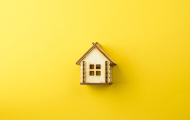 Miniature wooden toy house on a colored background. The concept of buying and selling apartments, houses. Real estate object. Copy space.