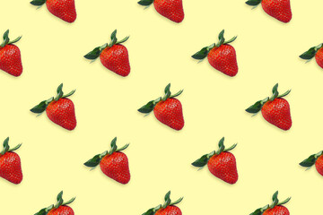 Seamless pattern of ripe red strawberries with leaves on a yellow background