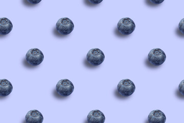 Seamless pattern of ripe round blueberries on a blue background