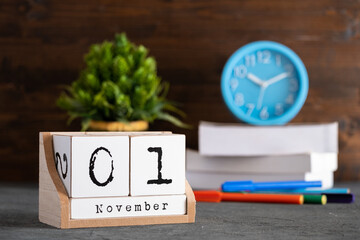 November 01st. November 01 wooden cube calendar with blur objects on background.