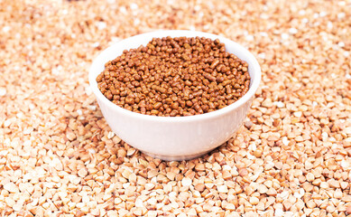 Granules of caffein-free buckwheat tea in a white plate on a background of raw buckwheat