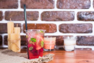 Cold raspberry lemonade in a plastic cup on a wooden table