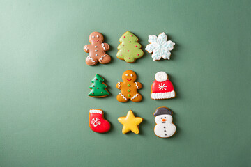 Christmas concept cookies on green surface flat lay
