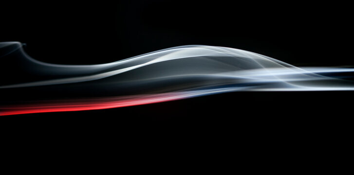 Colorful abstract Swirls of smoke against a black background that resemble a fighter aircraft