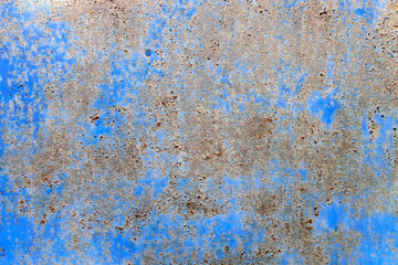 Fragment of an old peeling cracked rusty metal blue wall of an old barn