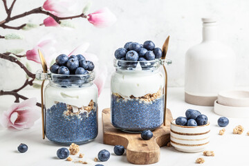Blueberry butterfly pea flower parfait in glass jars.