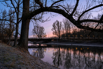 Brücke am Fluss mit morgendlicher Spiegelung im Wasser und schönen Lichtern