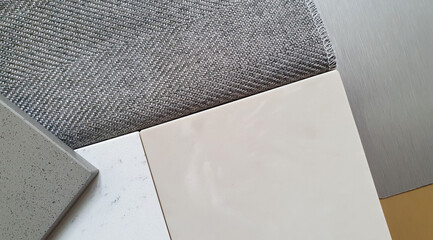 close up of interior mood and tone board showing combination of interior material containing artificial stone ,grey textile fabric for drapery ,gold and silver metallic laminated samples.