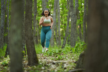 Naklejka na ściany i meble Plus size runner woman in the forest