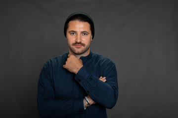 Fototapeta premium Portrait of smiling young hipster guy in hat and casual wear posing on isotaled grey background. Copy space. Concept of happy successful man, self-confidence, good offer, profession, freeelance work