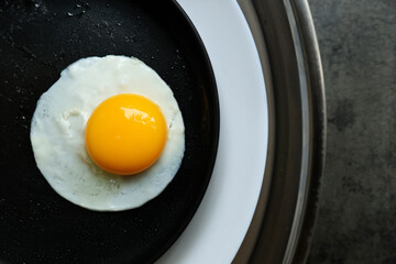 a fried egg in a pan, in 2 plate