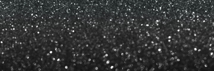 Black glitter bokeh circle glow blurred and blur abstract. Glittering shimmer bright luxury . White and silver glisten twinkle for texture wallpaper and background backdrop.
