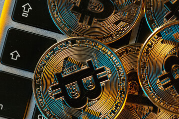 Groups of bitcoin is place on the keyboard of the laptop. Online payment technology, cryptocurrency trading and investment concept.