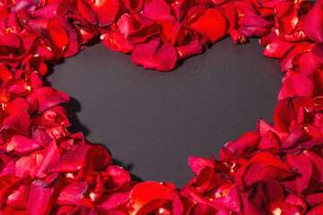 Fresh red roses petals background in the shape of a heart