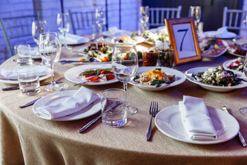 Table setting for a banquet or celebration. Empty wine glasses for spirits, champagne and juice. Set the table. Cloth napkins on a platter. Close-up