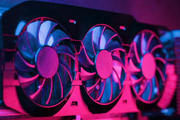 A graphics card with a row of fans with a cyanotic purple backlight in a futuristic design.