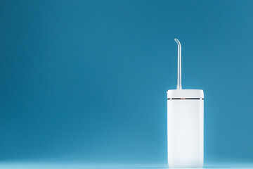 White oral irrigator on a blue background.