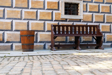 an old brown wooden barrel and bench in the historic courtyard with stone paving, castle Cesky Krumlov, Czech republic