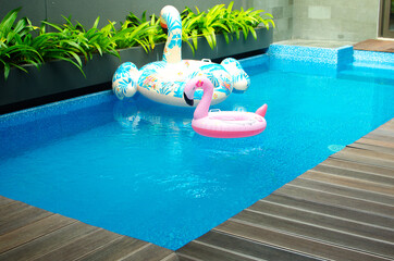 Hello summer. Pink inflatable flamingo in pool water for summer beach background. Trendy summer concept.
