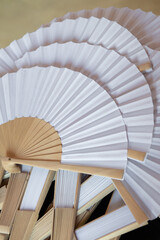 white and wooden fans as a wedding gift for guests