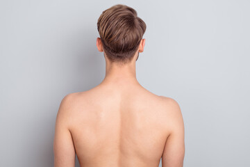 Back photo of young blond man without clothes isolated on grey color background