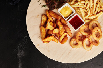 tackler with snacks on black textured background top view