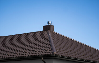 Brown corrugated metal profile roof installed on a modern house. The roof of corrugated sheet. Roofing of metal profile wavy shape. Modern roof made of metal. Metal roofing.