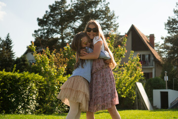 Two adorable sisters are enjoying their time in the backyard on a beautiful sunny day.