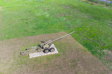 A large green cannon from the Second World War at the open-air memorial complex. Artillery gun.