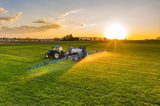 Farmer working in the field on a tractor until sunset.