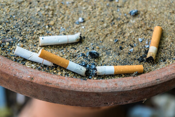 Trash of burned cigarette filled with cigarette butts and ashes.