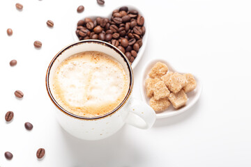 Mug with coffee and heart shaped plates with coffee beans and brown sugar on white background. Top view
