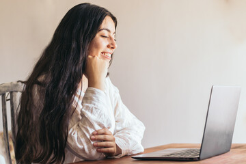 attractive young woman using her laptop in a desk