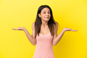 Fototapeta na wymiar Young caucasian woman isolated on yellow background having doubts while raising hands