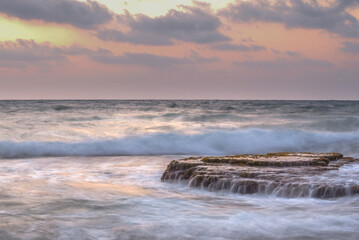 Obraz na płótnie Canvas Long exposure picture of a beautiful Mediterranean Sea sunset at the coastline near Haifa, Israel